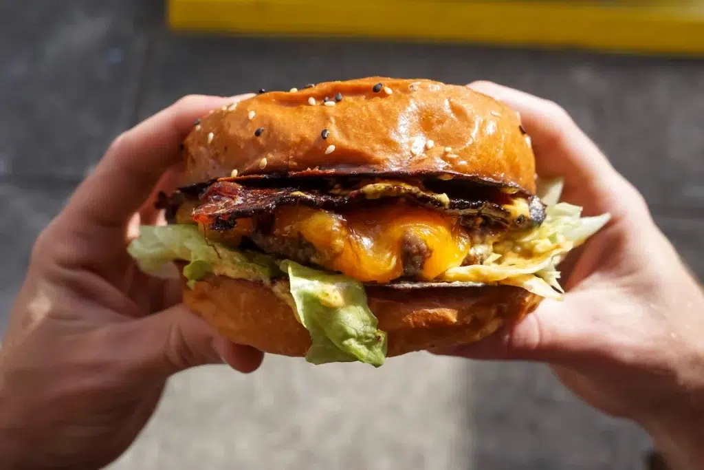 Hands holding a burger in Long Beach, California