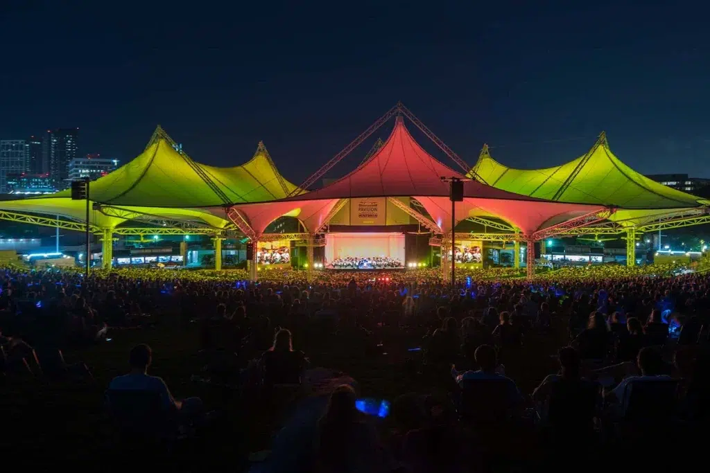 The Cynthia Woods Mitchell Pavilion at night with a live concert and lots of people in the audience
