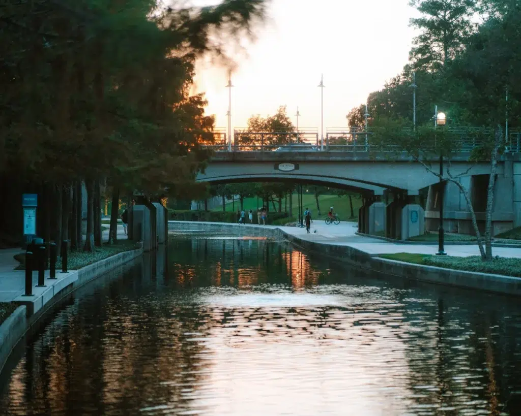 People walking along The Woodlands Waterway in Texas at sunset